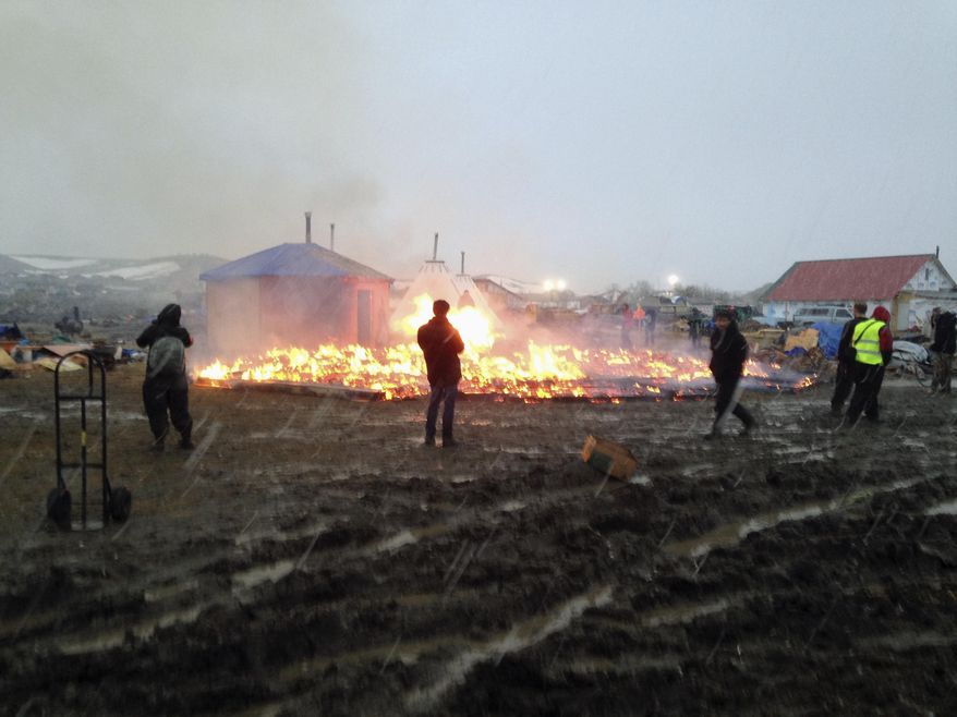 Dakota Access pipeline opponents burn structures in their main protest camp in southern North Dakota near Cannon Ball, N.D., on Wednesday, Feb. 22, 2017, as authorities prepare to shut down the camp in advance of spring flooding season. (AP Photo/James MacPherson)