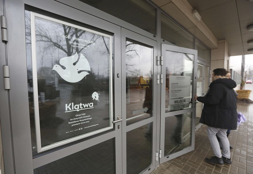 A person enters the ticket office of the Teatr Powszechny, a theater company, in Warsaw, Poland, Wednesday, Feb. 22, 2017. Prosecutors opened an investigation Wednesday into a new play that alludes to murdering the country's most powerful politician and has sexual scenes involving the cross and an image of the late Polish pope, St. John Paul II. (AP Photo/Czarek Sokolowski)