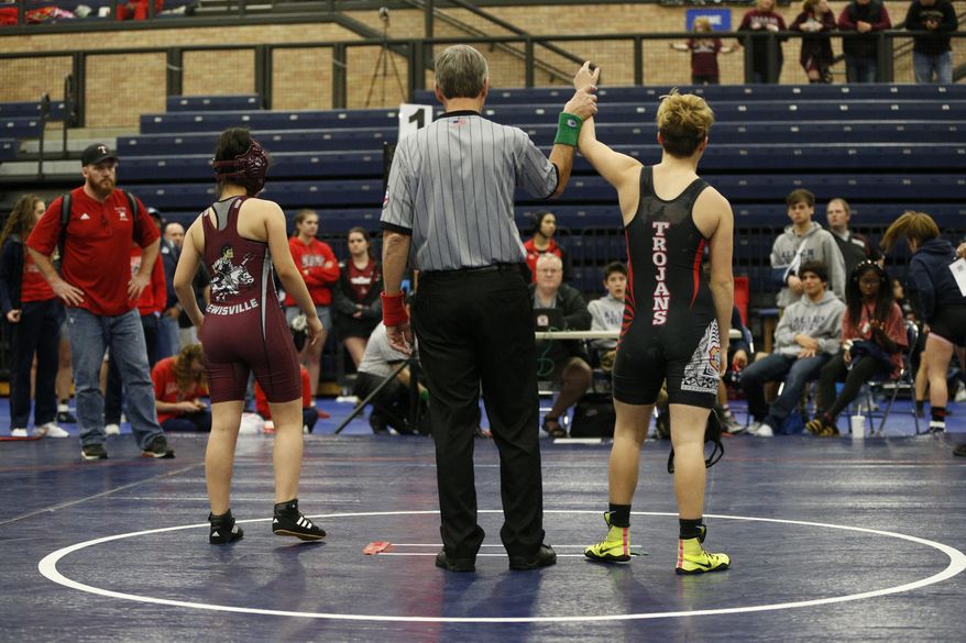 In this Feb. 18, 2017 photo, Euless Trinity's Mack Beggs, right, wins in a forfeit against Lewisville's Fatima Vaquerano, left, during the finals of the UIL Region 2-6A wrestling tournament at Allen High School in Allen, Texas. Beggs, who is transgender, is transitioning from female to male, won the girls regional championship. (Nathan Hunsinger/The Dallas Morning News via AP)
