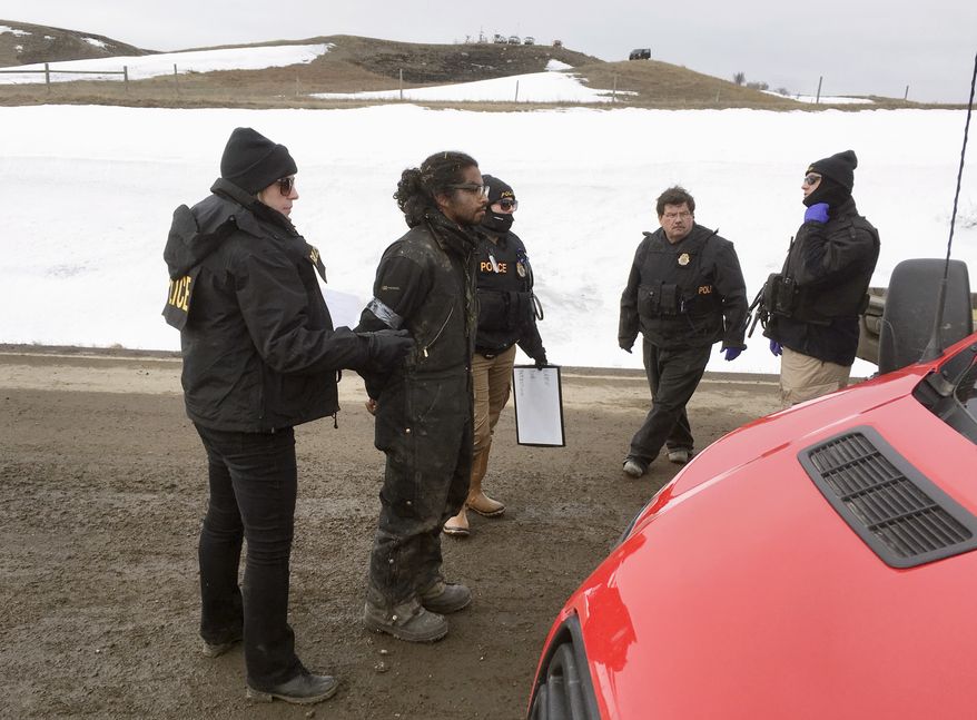 Authorities arrest one of the last remaining holdouts from the now-closed Dakota Access pipeline protest camp in southern North Dakota near Cannon Ball on Thursday, Feb. 23, 2017. Police made about several dozen arrests, and declared the camp cleared after about 3 1/2 hours. (Mike McCleary/Bismarck Tribune via AP)
