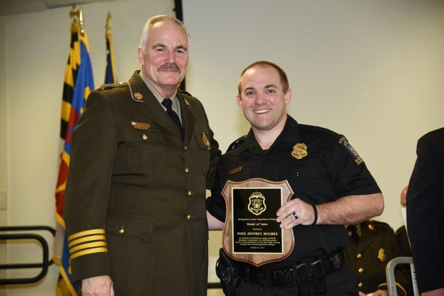 In this Feb. 22, 2017 photo provided by Montgomery County Police, Officer Jeff Hughes, right, poses for a photo with the Medal of Valor award with Chief Tom Manger in Gaithersburg, Md. Hughes, who was the first to respond to a gas explosion and fire that killed seven people last year has received his department's highest honor. (Montgomery County Police via AP)