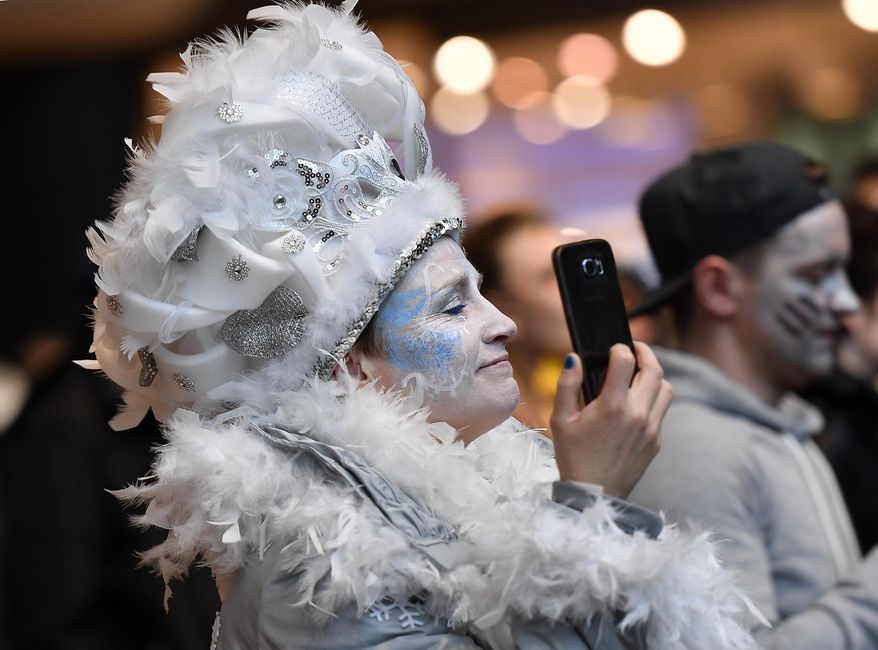 A reveler films with her phone when tens of thousands revelers dressed in carnival costumes celebrate the start of the street-carnival in Cologne, Germany, Thursday, Feb. 23, 2017. (AP Photo/Martin Meissner)