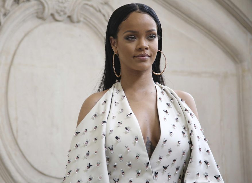 FILE - In this Sept. 30, 2016 file photo, singer Rihanna poses for photographers as she arrives to Christian Dior's Spring-Summer 2017 ready-to-wear fashion collection presented in Paris. Harvard University will present the singer with the Peter J. Gomes Humanitarian Award on Tuesday, Feb. 28, 2017, during a ceremony on campus in Cambridge, Mass., (AP Photo/Thibault Camus, File)