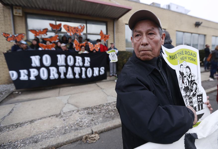 A man holds a sign prior to the start of an immigration protest outside of a detention center, Thursday, Feb. 23, 2017, in Elizabeth, N.J. More than 100 protesters lined the street outside of the detention center. They chanted against recent raids by federal immigration authorities and against President Donald Trump's proposed wall on the Mexican border. (AP Photo/Julio Cortez)