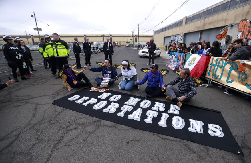Activists block a street as police officers look on during an immigration protest outside of a detention center, Thursday, Feb. 23, 2017, in Elizabeth, N.J. The activists were taken into custody after they refused to clear the street. (AP Photo/Julio Cortez)