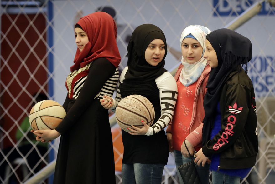In this picture taken on Sunday, Feb. 19, 2017, Syrian refugee girls attend a basketball training session at a private sports club, southern Beirut, Lebanon. Every Sunday the gymnasium in Beirut echoes with the shouting and laughter of dozens of children, mostly Syrian refugees enjoying a rare escape from a grim and cloistered life in exile. The Sport 4 Development program, run by the U.N. children's agency, aims to bring 12,000 children, mostly Syrian refugees, to blacktops and turf pitches this year to teach the basics of soccer and basketball, and to ease the pain of war and displacement. (AP Photo/Hussein Malla)