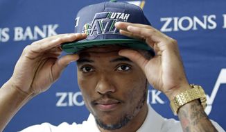 FILE - In this June 29, 2016 file photo, Utah Jazz NBA basketball team 2016 draft pick Joel Bolomboy adjusts his hat during a media availability at the Vivint Smart Home Arena in Salt Lake City.   Bolomboy has been back and forth between the NBA Developmental League’s Salt Lake City Stars and the Jazz 15 times since November. The NBA Developmental League has grown from an eight-team, largely overlooked sideshow to a 22-team league inching closer to becoming a legitimate minor league system since 2001. The league is no longer a final grasp for players clinging to a dream of playing professional basketball, but a respected avenue to get to the NBA. (AP Photo/Rick Bowmer)