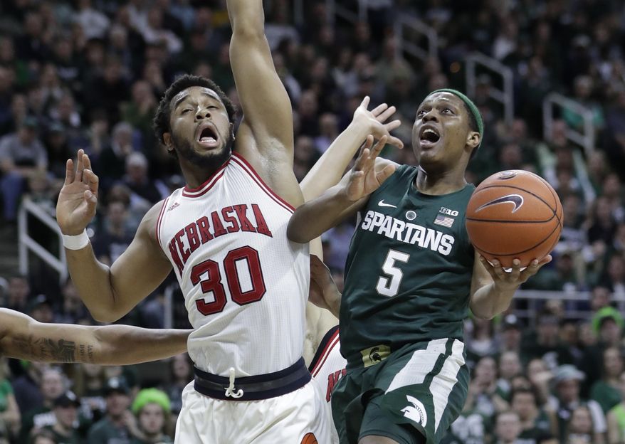 Michigan State guard Cassius Winston (5) makes a layup as Nebraska forward Ed Morrow (30) defends during the second half of an NCAA college basketball game, Thursday, Feb. 23, 2017, in East Lansing, Mich. (AP Photo/Carlos Osorio)