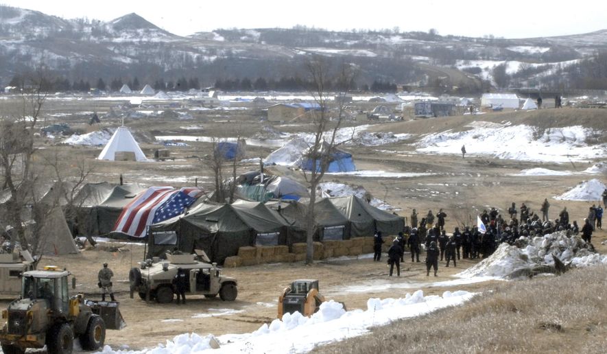 Law enforcement enters the Oceti Sakowin camp to begin arresting Dakota Access Pipeline protesters  in Morton County, Thursday, Feb. 23, 2017, near Cannon Ball, N.D. As the arrests were underway law enforcement personnel drove several large construction equipment into the camp to begin the cleanup process of razing tents and structures.  (Mike McCleary/The Bismarck Tribune via AP, Pool) ** FILE **