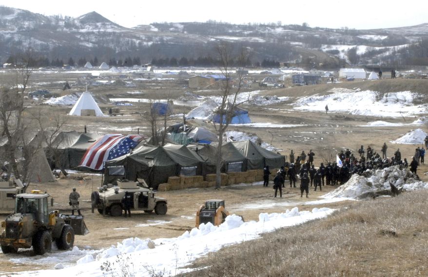 Law enforcement enters the Oceti Sakowin camp to begin arresting Dakota Access Pipeline protesters  in Morton County, Thursday, Feb. 23, 2017, near Cannon Ball, N.D. As the arrests were underway law enforcement personnel drove several large construction equipment into the camp to begin the cleanup process of razing tents and structures.  (Mike McCleary/The Bismarck Tribune via AP, Pool) ** FILE **