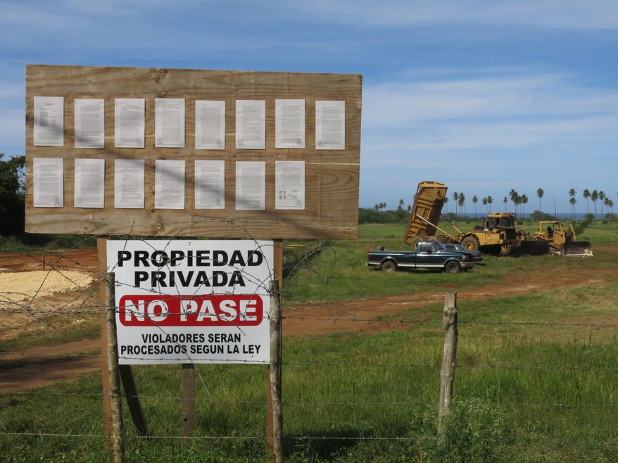 In this Feb. 16, 2017 photo, a no trespassing sign stands at Wilderness Beach, in Aguadilla, a lush corner in northwest Puerto Rico that has remained largely untouched since Christopher Columbus landed there in his second voyage to the New World. Developers and officials in Puerto Rico want to transform Wilderness Beach, a destination for big-wave surfing, into a more traditional tourism destination with a hotel and villas. The project has drawn opposition by people who say that one of the last few undeveloped stretches of the northwest coast should be left alone despite the economic benefits for an island mired in recession. (AP Photo/Danica Coto)