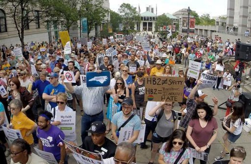 FILE - In this April 25, 2016 file photo, protesters rally against House Bill 2 in Raleigh, N.C., which would require transgender people to use restrooms in many public buildings that match their original gender. Because of the bill, several major sports organizations shifted events away from North Carolina and businesses such as PayPal decided not to expand in the state. In November, Republican Pat McCrory, who signed and defended the bill, became the only incumbent governor to lose in the general election. (Chuck Liddy/The News & Observer via AP)