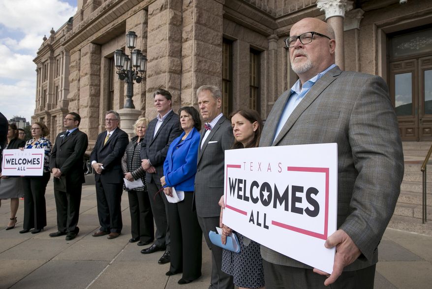 FILE - In this Jan. 11, 2017, file photo, Brad Kent, chief sales and services officer for Visit Dallas, holds a sign at a news conference at the state capitol in Austin, Texas, to oppose a Texas "bathroom bill." Bills to curtail transgender people's access to public restrooms are pending in a dozen states, but even in conservative bastions such as Texas and Arkansas they may be doomed by high-powered opposition. (Jay Janner/Austin American-Statesman via AP, File)