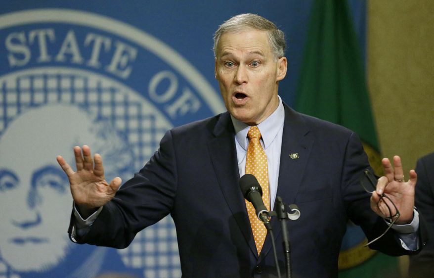 Washington Gov. Jay Inslee talks to reporters, Thursday, Feb. 23, 2017, at the Capitol in Olympia, Wash., after he signed an executive order to ensure that state workers don't help carry out President Donald Trump's immigration policies. Trump has said he wants to expand the number of deportations of people in the country illegally, and Inslee said Thursday that his order reaffirms the state's commitment to tolerance and ensures that state workers roles are to provide services for residents and not to enforce immigration statutes. (AP Photo/Ted S. Warren)