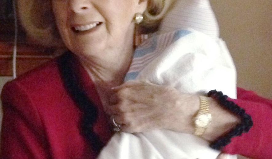 ADVANCE FOR USE MONDAY, FEB. 27, 2017 AT 1 A.M. EDT AND THEREAFTER-In this Jan. 23, 2015 photo provided by Rachael Bryant, Word of Faith Fellowship leader Jane Whaley holds the newborn infant of one of her congregants in a hospital in Shelby, N.C. Word of Faith Fellowship has been scrutinized on numerous occasions by law enforcement, social services agencies and the news media since the early 1990s_ all without significant impact, mostly because followers refused to cooperate. (Rachael Bryant via AP)