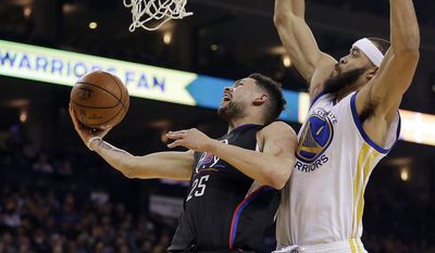 Los Angeles Clippers&#x27; Austin Rivers, left, lays up a shot past Golden State Warriors&#x27; JaVale McGee (1) during the first half of an NBA basketball game Thursday, Feb. 23, 2017, in Oakland, Calif. (AP Photo/Ben Margot)