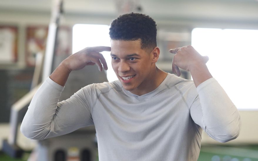 In this Thursday, Feb. 16, 2017, photograph, Air Force wide receiver Jalen Robinette jokes with trainers as he takes part in a drill to prepare for the NFL Combine at a workout facility in Centennial, Colo. Robinette is taking six courses at the academy while preparing for dual careers as an Air Force officer and an NFL wide receiver. (AP Photo/David Zalubowski)