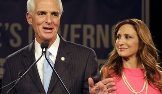 FILE- In this Nov. 4, 2014 file photo, Charlie Crist gestures as he stands with his wife Carole during speech in Tampa, Fla. After nine years of marriage, U.S Rep. Charlie Crist has filed for divorce. (AP Photo/Chris O&#39;Meara, File)