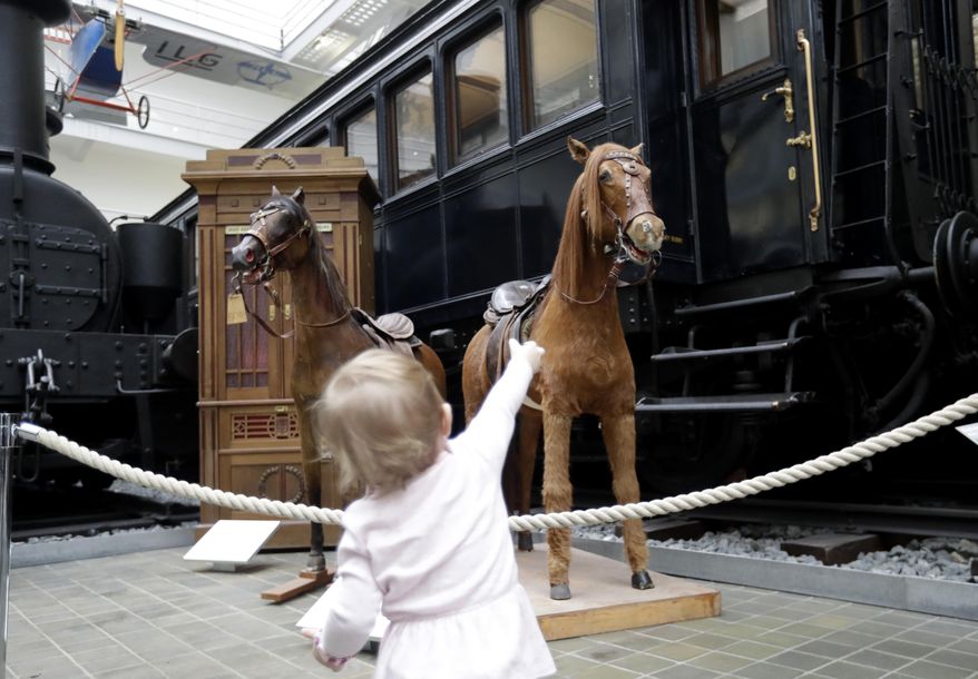 In this picture taken on Thursday, Feb. 23, 2017, a young girl looks at restored stuffed horses that were part of a historical carousel put on display at the National Technical Museum in Prague, Czech Republic. The museum acquired the carousel in 2004 from its private owners and had finally secured enough money to finance a major renovation project. (AP Photo/Petr David Josek)