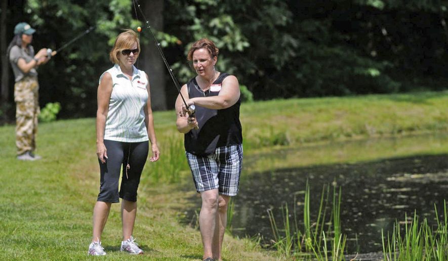 ADVANCE FOR USE SATURDAY, FEB. 25, AND THEREAFTER – FILE – In this Aug. 17, 2013, file photo, Theresa Santai-Gaffney, right, shows Tina Fink, left, of Pottsville, Pa., techniques for casting a fishing rod during the annual Schuylkill County Women's Outdoor Day at Friedensburg Fish & Game in Pine Grove, Pa. Only 18 percent of anglers in Pennsylvania are women, and they drop out of the sport faster than men, Pennsylvania Fish and Boat Commission Executive Director John Arway said Feb. 15, 2017, in his annual report to the legislature. (Jacqueline Dormer/Republican Herald via AP, File)
