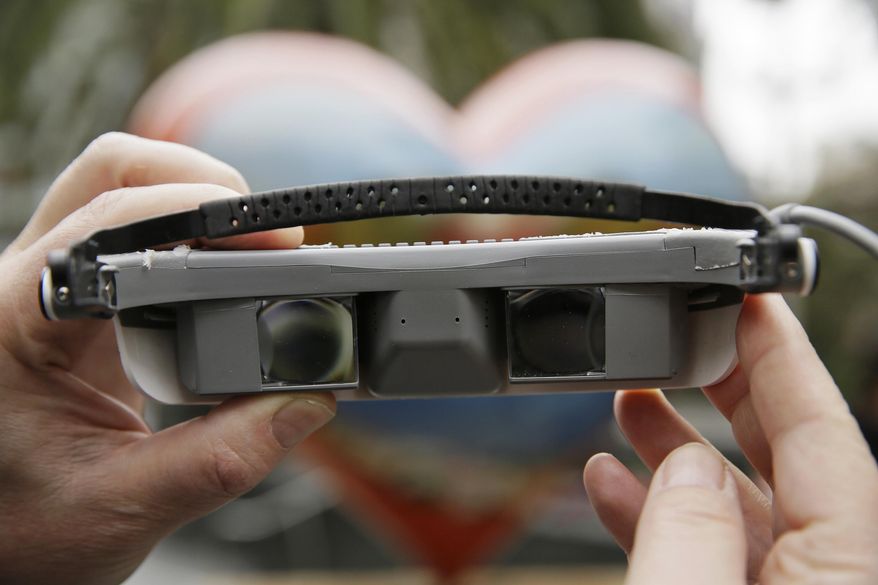 In this photo taken Thursday, Feb. 2, 2017, eSight CEO and President Brian Mech holds up a pair electronic glasses at Union Square San Francisco. The glasses enable the legally blind to see. (AP Photo/Eric Risberg)