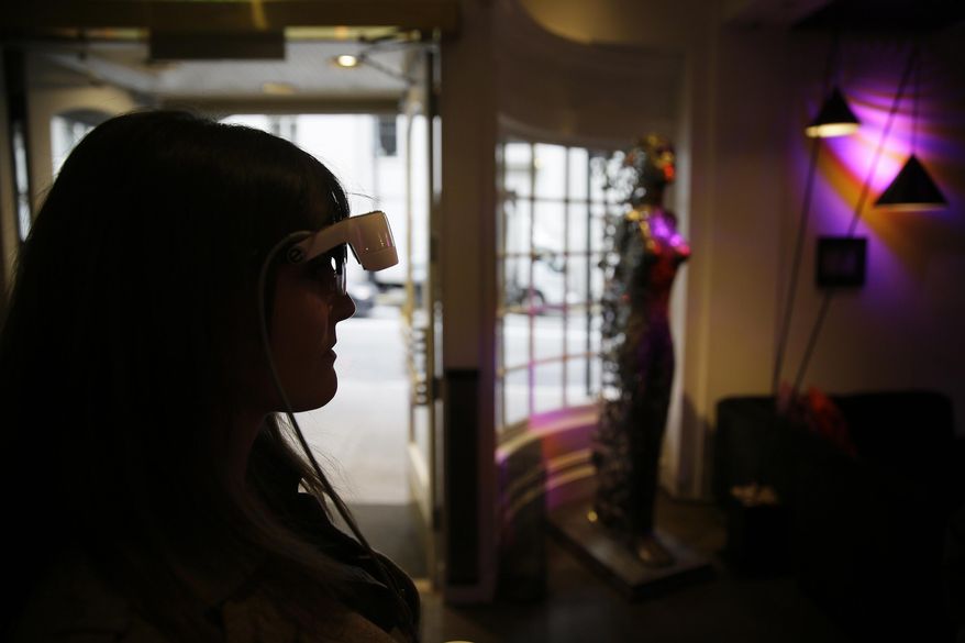 In this photo taken Thursday, Feb. 2, 2017, Yvonne Felix wears eSight electronic glasses and looks around the lobby of the Hotel Zeppelin during a visit to San Francisco. The glasses enable the legally blind to see. Felix was diagnosed with Stargardt's disease after being hit by a car at the age of seven. (AP Photo/Eric Risberg)