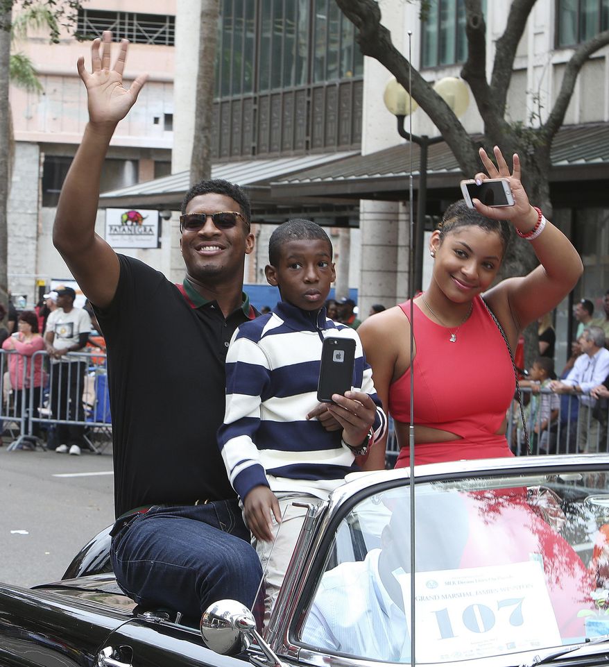 FILE - In this Jan. 16, 2017, file photo, Tampa Bay Buccaneers quarterback Jameis Winston, his younger brother Jonah Winston, and his girlfriend Breion Allen, all ride in a car during the Martin Luther King Jr. Day parade in St. Petersburg, Fla. Winston, who was accused of raping another student when he was in college, says he made a “poor word choice” in comments about women in a recent talk to students at a Florida elementary school. The Tampa Bay Times reports Winston spoke to third- through fifth-grade students at Melrose Elementary in St. Petersburg on Wednesday, Feb. 22, 2017, telling them about his three rules of life. When the kids got fidgety, Winston told the boys to stand up, reminding them that they’re “strong.” Then, he said the “ladies” are “supposed to be silent, polite, gentle.” (Scott Keeler/Tampa Bay Times via AP, File)