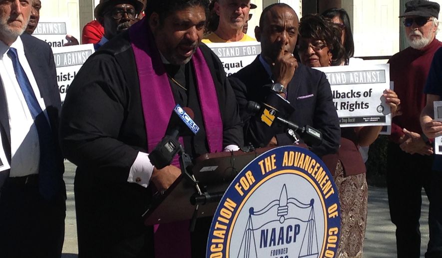 North Carolina's NAACP leader The Rev. William Barber speaks at a news conference on Friday, Feb. 24, 2016, in Raleigh, N.C., while the national NAACP president Cornell Brooks looks on. The two were announcing the first steps in a national economic boycott of the state over conservative policies including a law limiting LGBT rights. (AP Photo/Jonathan Drew)