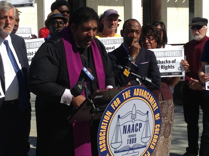 North Carolina's NAACP leader The Rev. William Barber speaks at a news conference on Friday, Feb. 24, 2016, in Raleigh, N.C., while the national NAACP president Cornell Brooks looks on. The two were announcing the first steps in a national economic boycott of the state over conservative policies including a law limiting LGBT rights. (AP Photo/Jonathan Drew)