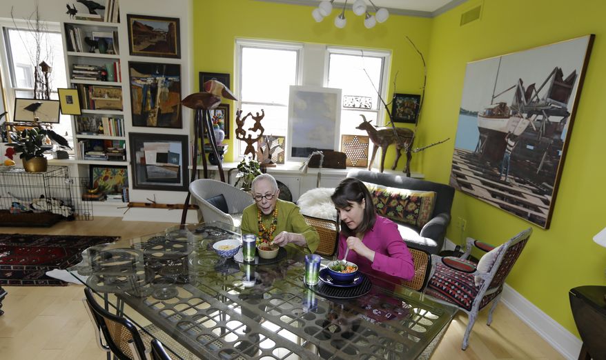 In this Friday, Feb. 17, 2017 photo, Laura Berick, left, has lunch with Justine Myers at Berick's home in Judson Manor, in Cleveland. In a research project, graduate-level students live among residents of the Judson Manor retirement home. The study looks at the impact of isolation and loneliness, aging and stereotypes of retirees by students and vice versa. Myers is an artist-in-residence at Judson Park. She is an Oberlin College graduate student studying music. (AP Photo/Tony Dejak)
