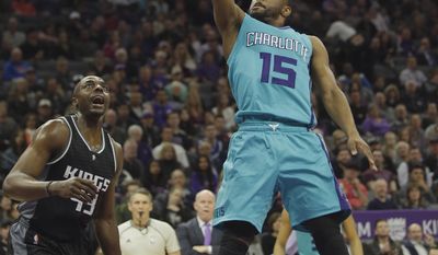 Charlotte Hornets guard Kemba Walker, right, goes to the basket as Sacramento Kings forward Anthony Tolliver, left, looks on during the first half of an NBA basketball game Saturday, Feb. 25, 2017, in Sacramento, Calif. (AP Photo/Rich Pedroncelli)