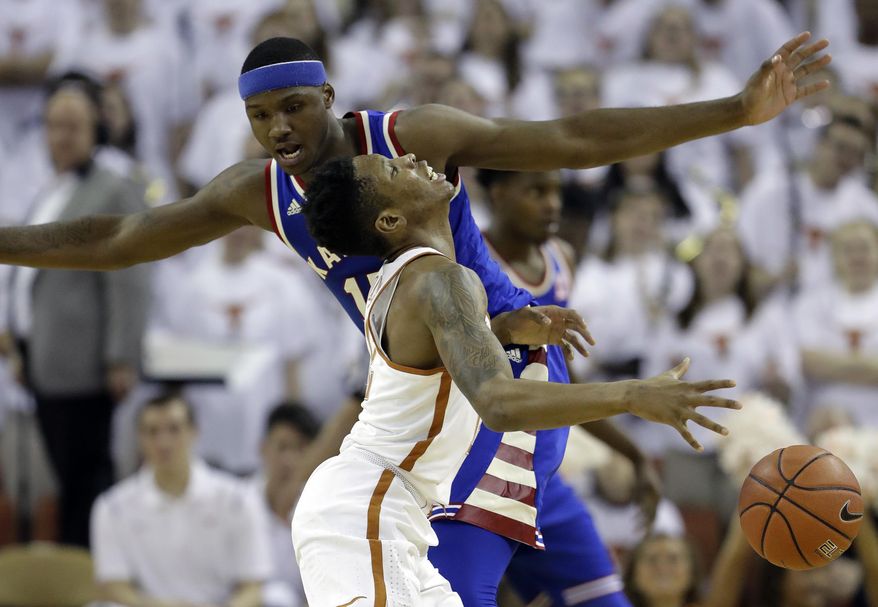 Texas guard Kerwin Roach Jr. (12) is fouled by Kansas forward Carlton Bragg Jr. (15) during the first half of an NCAA college basketball game, Saturday, Feb. 25, 2017, in Austin, Texas. (AP Photo/Eric Gay)