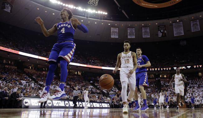 Kansas guard Devonte&#x27; Graham (4) reacts after he scored over Texas guard Eric Davis Jr. (10) during the first half of an NCAA college basketball game, Saturday, Feb. 25, 2017, in Austin, Texas. (AP Photo/Eric Gay)