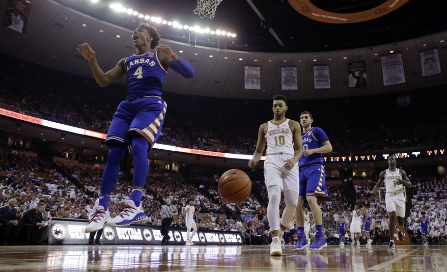 Kansas guard Devonte' Graham (4) reacts after he scored over Texas guard Eric Davis Jr. (10) during the first half of an NCAA college basketball game, Saturday, Feb. 25, 2017, in Austin, Texas. (AP Photo/Eric Gay)