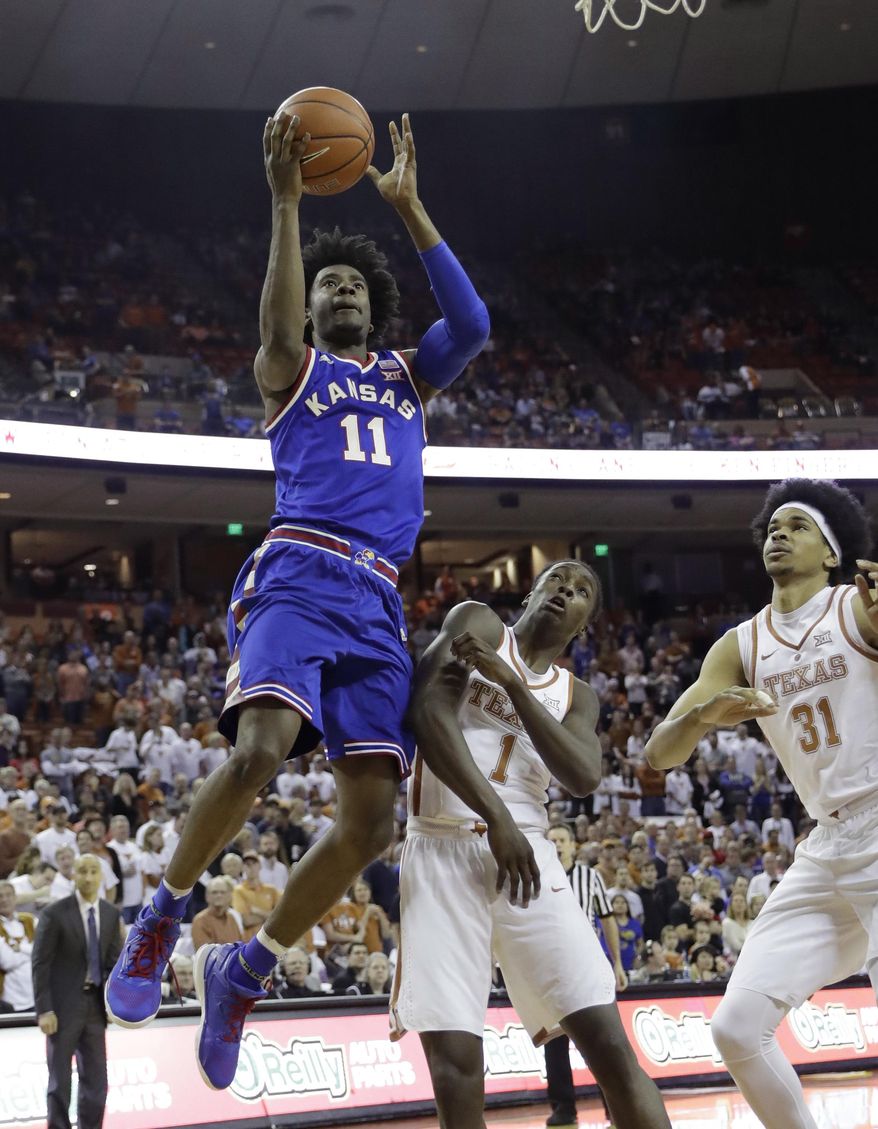 Kansas guard Josh Jackson (11) shoots over Texas defenders Andrew Jones (1) and Jarrett Allen (31) during the first half of an NCAA college basketball game, Saturday, Feb. 25, 2017, in Austin, Texas. (AP Photo/Eric Gay)