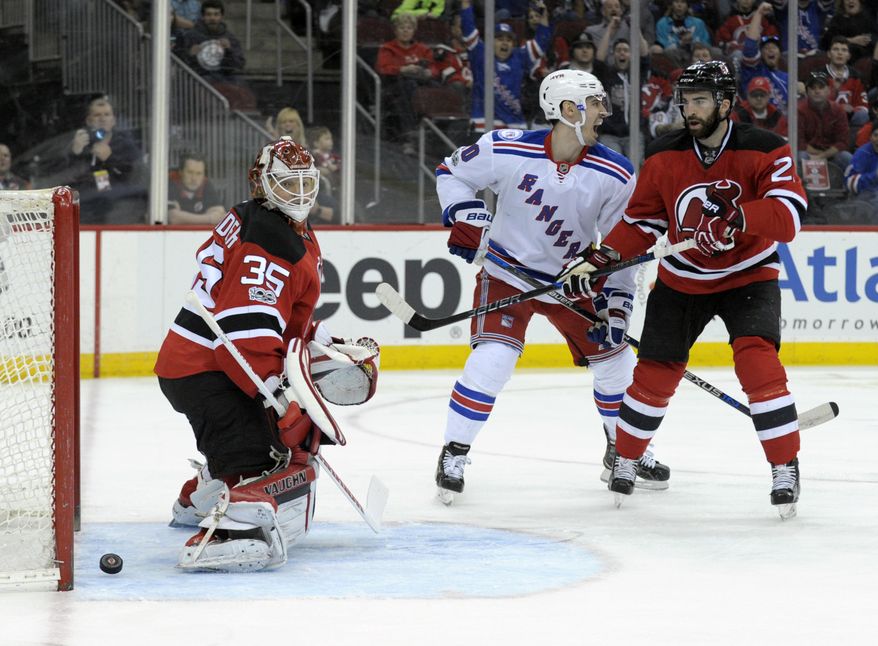 New York Rangers&#39; Chris Kreider, center, celebrates his goal as New Jersey Devils goaltender Cory Schneider, left, eyes the puck coming out of the net and Devils&#39; Kyle Palmieri looks on during the first period of an NHL hockey game Saturday, Feb. 25, 2017, in Newark, N.J. (AP Photo/Bill Kostroun)