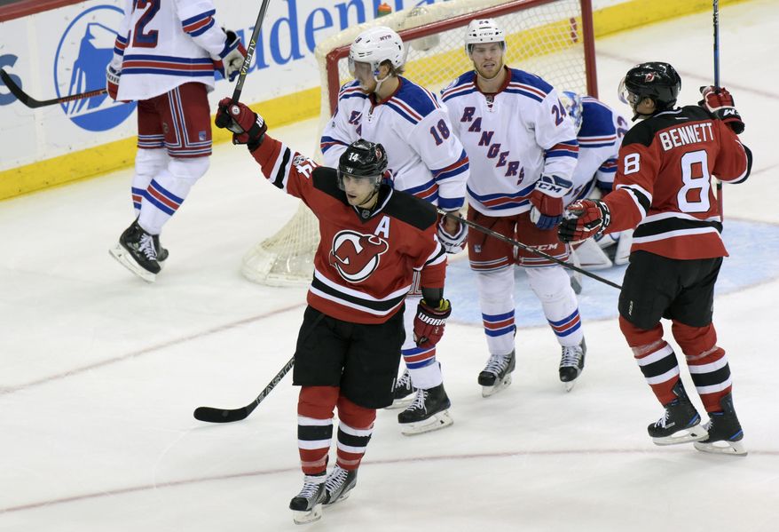 New Jersey Devils&#39; Adam Henrique (14) celebrates his goal as New York Rangers&#39; Marc Staal (18) and Oscar Lindberg (24) look on during the second period of an NHL hockey game Saturday, Feb. 25, 2017, in Newark, N.J. (AP Photo/Bill Kostroun)