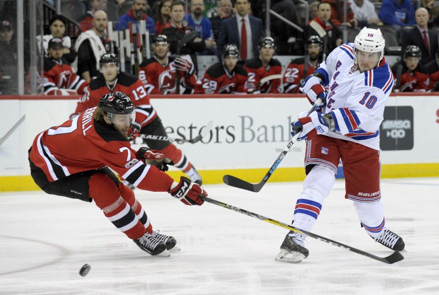 New York Rangers&#39; J.T. Miller takes a shot as New Jersey Devils&#39; Jon Merrill defends during the first period of an NHL hockey game Saturday, Feb. 25, 2017, in Newark, N.J. (AP Photo/Bill Kostroun)