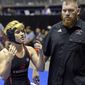 Mack Beggs, left, a transgender wrestler from Euless Trinity High School, stands with his coach Travis Clark during a quarterfinal match against Mya Engert, of Amarillo Tascosa, during the State Wrestling Tournament, Friday, Feb. 24, 2017, in Cypress, Texas. Beggs was born a girl and is transitioning to male but wrestles in the girls division. ( Melissa Phillip/Houston Chronicle via AP)