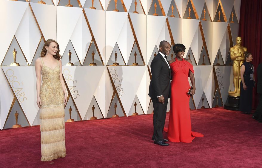 Emma Stone, from left, Julius Tennon, and Viola Davis arrive at the Oscars on Sunday, Feb. 26, 2017, at the Dolby Theatre in Los Angeles. (Photo by Jordan Strauss/Invision/AP)