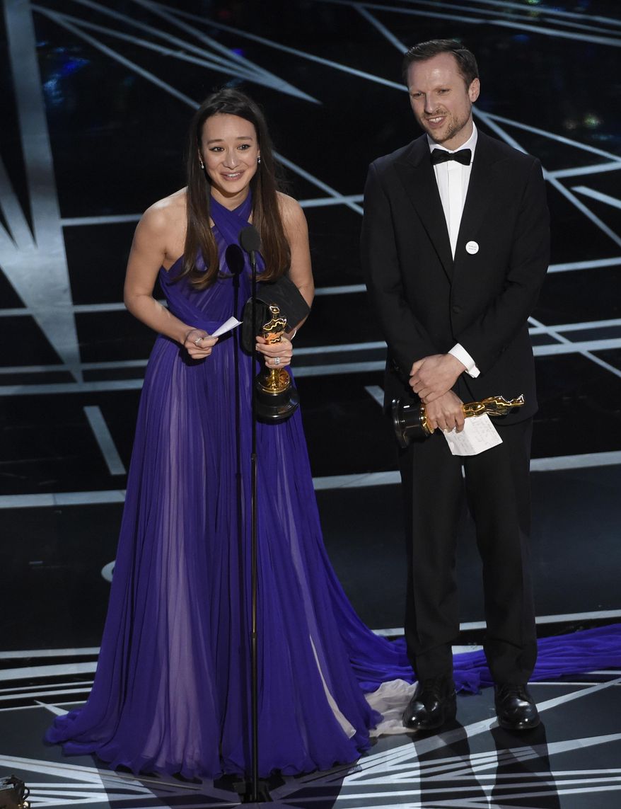 Joanna Natasegara, left, and Orlando von Einsiedel accept the award for best documentary short subject for "The White Helmets" at the Oscars on Sunday, Feb. 26, 2017, at the Dolby Theatre in Los Angeles. (Photo by Chris Pizzello/Invision/AP)