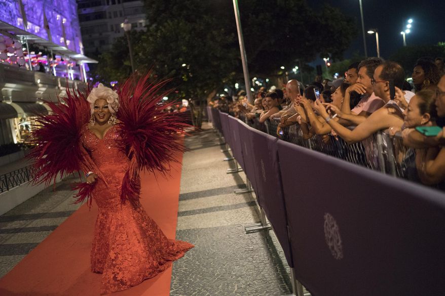 A guest in a costume walks on the red carpet as she arrives to a traditional Carnival ball at the Copacabana Palace hotel in Rio de Janeiro, Brazil, Saturday, Feb. 25, 2017. In stark contrast to the hundreds of hard-charging street parties across Rio that are open to anyone, the "Baile do Copa" bills itself as a fairytale event where the country's elite can see and be seen in a hotel known for both opulence and a lengthy tradition of welcoming world leaders and stars. (AP Photo/Leo Correa)