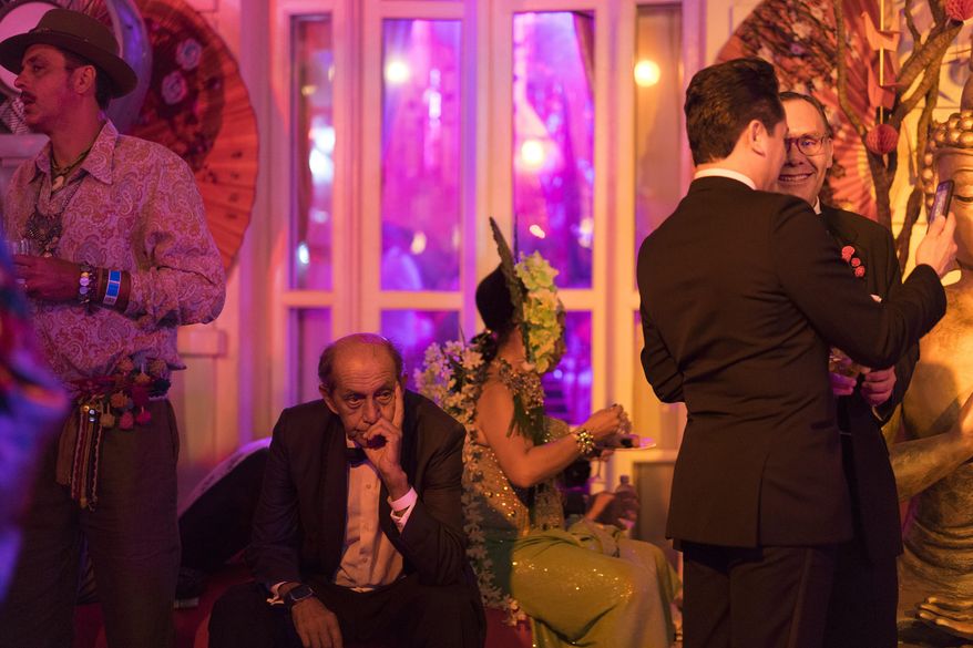 A guest, second left, reacts as he attends a traditional Carnival ball at the Copacabana Palace hotel in Rio de Janeiro, Brazil, Saturday, Feb. 25, 2017. In stark contrast to the hundreds of hard-charging street parties across Rio that are open to anyone, the "Baile do Copa" bills itself as a fairytale event where the country's elite can see and be seen in a hotel known for both opulence and a lengthy tradition of welcoming world leaders and stars. (AP Photo/Leo Correa)