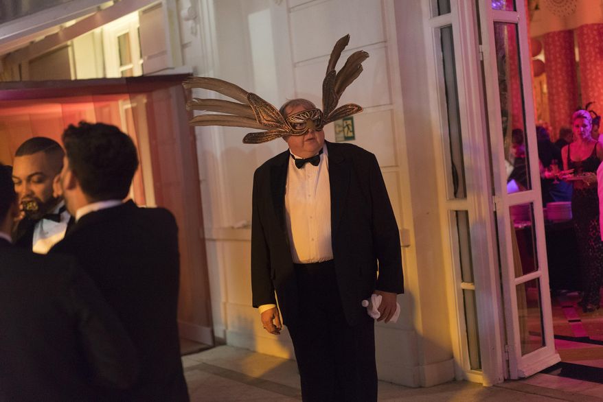 A guest wearing a mask attends a traditional Carnival ball at the Copacabana Palace hotel in Rio de Janeiro, Brazil, Saturday, Feb. 25, 2017. In stark contrast to the hundreds of hard-charging street parties across Rio that are open to anyone, the "Baile do Copa" bills itself as a fairytale event where the country's elite can see and be seen in a hotel known for both opulence and a lengthy tradition of welcoming world leaders and stars. (AP Photo/Leo Correa)