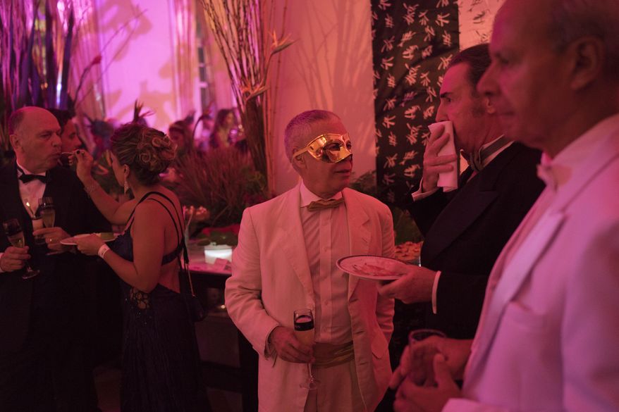 A masked guest attends a traditional Carnival ball at the Copacabana Palace hotel in Rio de Janeiro, Brazil, Saturday, Feb. 25, 2017. In stark contrast to the hundreds of hard-charging street parties across Rio that are open to anyone, the "Baile do Copa" bills itself as a fairytale event where the country's elite can see and be seen in a hotel known for both opulence and a lengthy tradition of welcoming world leaders and stars. (AP Photo/Leo Correa)