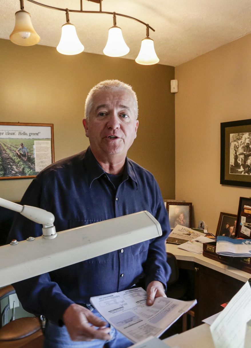 In this Feb. 2, 2017 photo, farmer Don Schuller holds his tax statement, at his home office in Wymore, Neb. When six people went to prison for the 1985 rape and murder of a 68-year-old Nebraska woman, county officials figured they had put the gruesome high-profile case behind them. But after DNA evidence exonerated all six of the accused in 2008, the rural farming county just south of Lincoln found itself facing a new problem, a $28 million federal judgment that could force officials to file for bankruptcy. Schuller estimates his county property tax bill could quadruple if officials are forced to pay the judgment all in one year. (AP Photo/Nati Harnik)