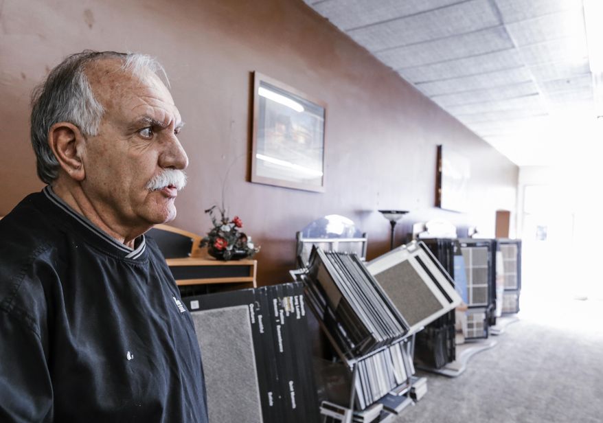 In this Feb. 2, 2017, photo, Darrell Fletcher stands in his carpet and decorating shop in downtown Beatrice, Neb. When six people went to prison for the 1985 rape and murder of a 68-year-old Nebraska woman, county officials figured they had put the gruesome high-profile case behind them. But after DNA evidence exonerated all six of the accused in 2008, the rural farming county just south of Lincoln found itself facing a new problem - a $28 million federal judgment that could force officials to file for bankruptcy. Fletcher said it could be devastating, "It's going to affect the whole town, businesses, farmers, you name it." (AP Photo/Nati Harnik)