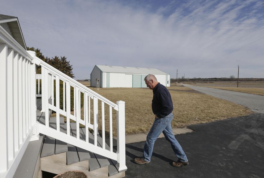 In this Feb. 2, 2017 photo, farmer Don Schuller walks outside his home in Wymore, Neb. When six people went to prison for the 1985 rape and murder of a 68-year-old Nebraska woman, county officials figured they had put the gruesome high-profile case behind them. But after DNA evidence exonerated all six of the accused in 2008, the rural farming county just south of Lincoln found itself facing a new problem, a $28 million federal judgment that could force officials to file for bankruptcy. Schuller estimates his county property tax bill could quadruple if officials are forced to pay the judgment all in one year. (AP Photo/Nati Harnik)