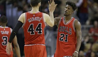 Chicago Bulls&#39; Nikola Mirotic (44) and Jimmy Butler (21) celebrate late in the second half of an NBA basketball game against the Cleveland Cavaliers, Saturday, Feb. 25, 2017, in Cleveland. (AP Photo/Tony Dejak)
