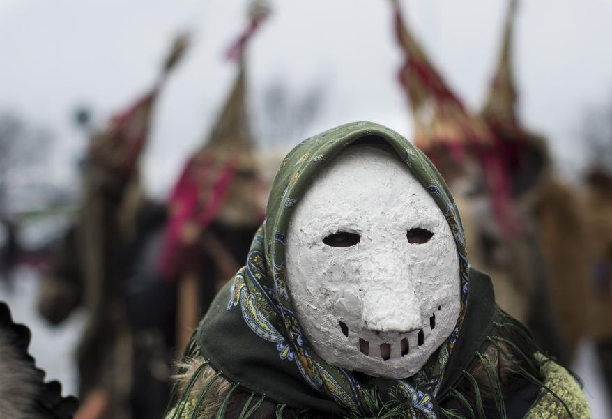 A reveller wearing a mask takes part in the International Mask Festival in Riga, Latvia, Sunday, Feb. 26, 2017. (AP Photo/Mindaugas Kulbis)